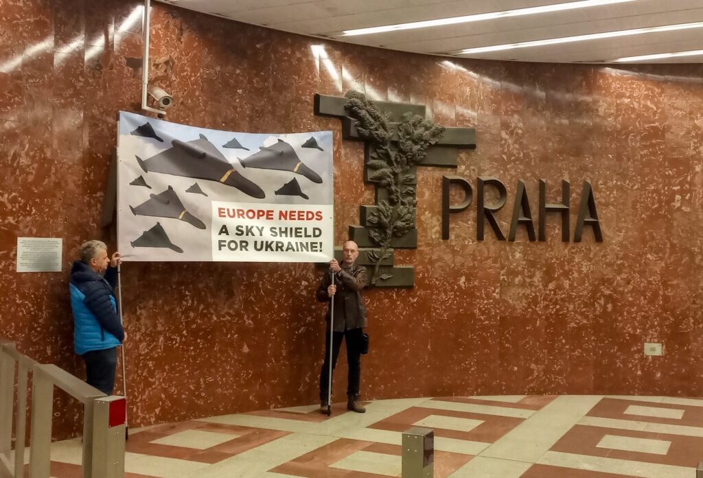 Activists covering sculpture Moscow-Prague on Prague metro station Anděl by large banner with drone swarms and text EUROPE NEEDS A SKY SHIELD FOR UKRAINE! - this first picture is showing that initially, Moscow large letter of sculpture was covered.
